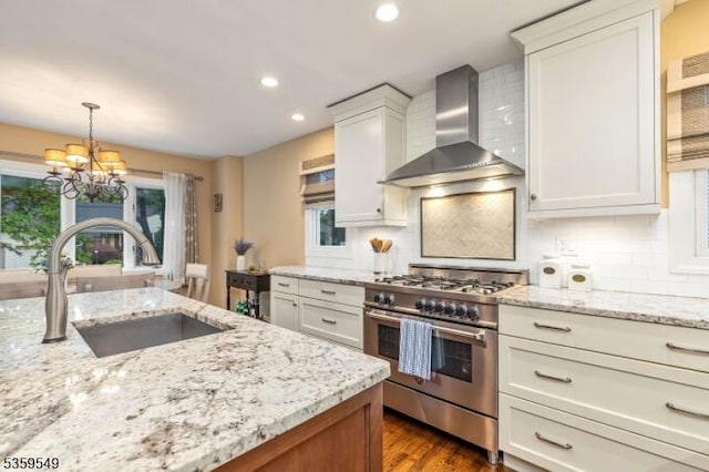 55 Nomahegan Ct, Cranford Twp, NJ 07016 - kitchen with high end range, a sink, wall chimney exhaust hood, a chandelier, and healthy amount of natural light
