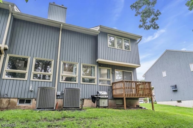 23 Bond St, Bridgewater Twp, NJ 08807 - rear view of house featuring a deck, a lawn, a chimney, and board and batten siding