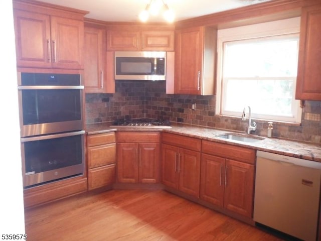 300 Jefferson Ave, Rahway City, NJ 07065 - kitchen featuring appliances with stainless steel finishes, a sink, decorative backsplash, and light stone countertops