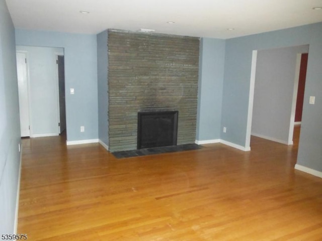 300 Jefferson Ave, Rahway City, NJ 07065 - unfurnished living room with a large fireplace, wood finished floors, and baseboards