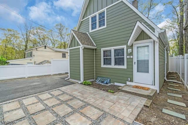 10 Rutgers Way, Hopatcong Boro, NJ 07843 - back of property with board and batten siding, a patio area, a fenced backyard, and roof with shingles