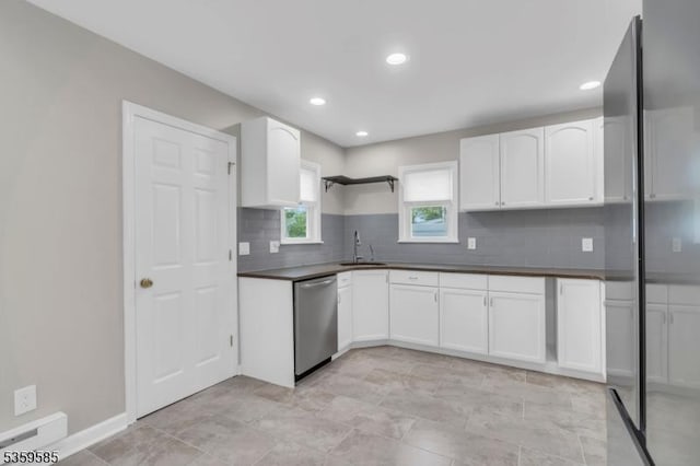 10 Rutgers Way, Hopatcong Boro, NJ 07843 - kitchen featuring stainless steel dishwasher, a sink, dark countertops, backsplash, and white cabinetry
