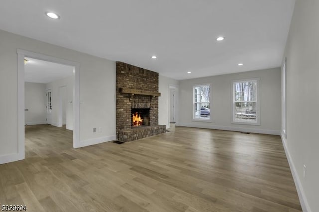 129 Sandy Ridge Rd, Delaware Twp, NJ 08559 - unfurnished living room with light wood finished floors, baseboards, a brick fireplace, and recessed lighting