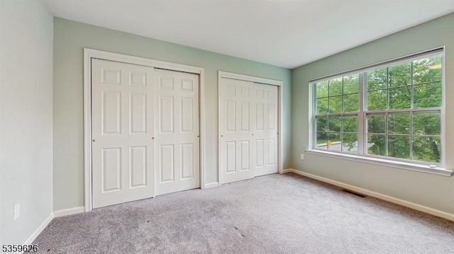 612 Magnolia Rd, North Brunswick Twp, NJ 08902 - unfurnished bedroom featuring two closets, carpet, and baseboards