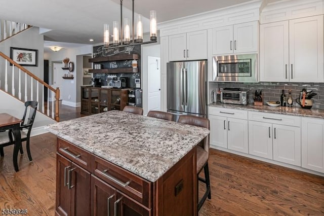25 Wessex Ln, Montgomery Twp, NJ 08558 - kitchen with appliances with stainless steel finishes, tasteful backsplash, a breakfast bar, white cabinetry, and dark wood finished floors