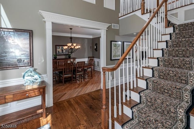25 Wessex Ln, Montgomery Twp, NJ 08558 - stairs with a chandelier, wood finished floors, crown molding, a wainscoted wall, and decorative columns