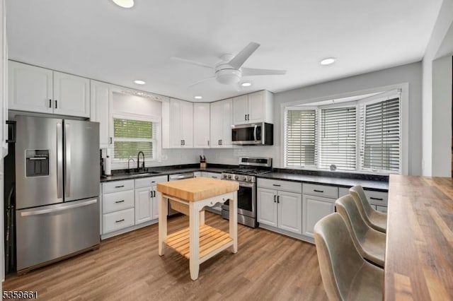 46 Sunrise Ter, Cedar Grove Twp, NJ 07009 - kitchen featuring stainless steel appliances, a sink, white cabinetry, decorative backsplash, and recessed lighting