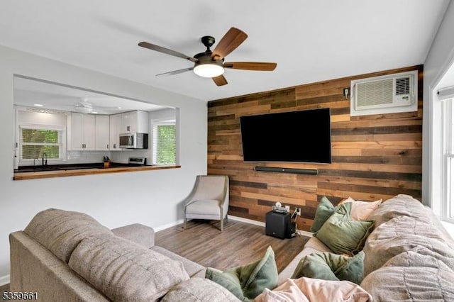 46 Sunrise Ter, Cedar Grove Twp, NJ 07009 - living room featuring a ceiling fan, an accent wall, wooden walls, baseboards, and wood finished floors