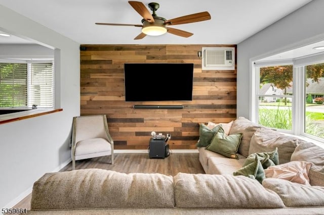 46 Sunrise Ter, Cedar Grove Twp, NJ 07009 - living room with a wall mounted AC, wood walls, ceiling fan, wood finished floors, and baseboards