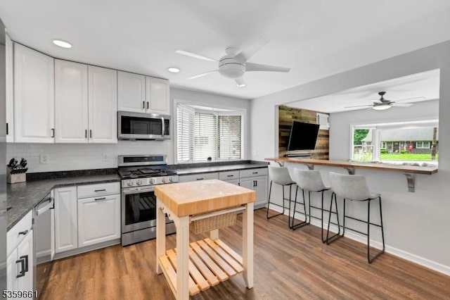 46 Sunrise Ter, Cedar Grove Twp, NJ 07009 - kitchen featuring stainless steel appliances, ceiling fan, white cabinets, dark countertops, and backsplash