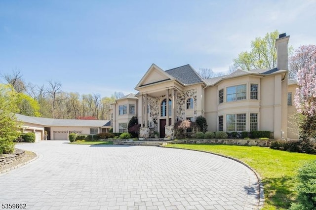 23 Stoningham Dr, Warren Twp, NJ 07059 - greek revival inspired property featuring curved driveway, a chimney, a front yard, a garage, and stucco siding