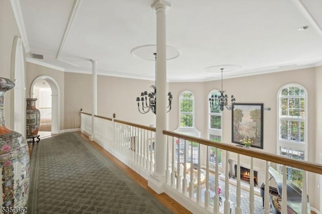 23 Stoningham Dr, Warren Twp, NJ 07059 - hallway with crown molding, wood finished floors, healthy amount of natural light, a chandelier, and arched walkways