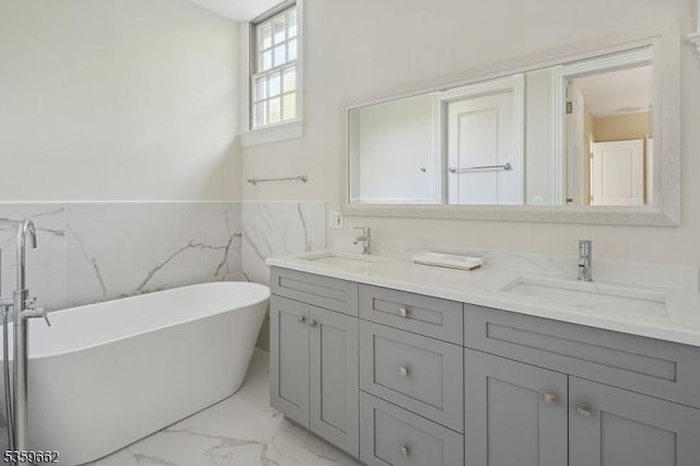 23 Stoningham Dr, Warren Twp, NJ 07059 - bathroom featuring marble finish flooring, double vanity, a freestanding bath, a wainscoted wall, and tile walls