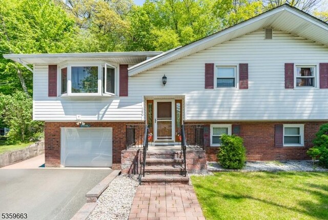 580 Eric Ln, Mount Arlington Boro, NJ 07850 - split foyer home with brick siding, driveway, and an attached garage