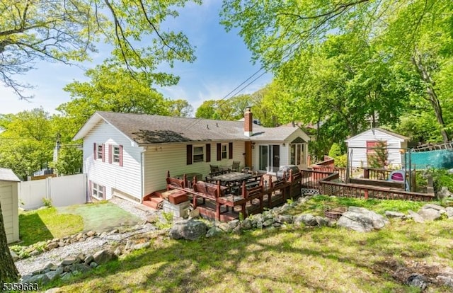 580 Eric Ln, Mount Arlington Boro, NJ 07850 - back of property with a chimney, a deck, and roof with shingles