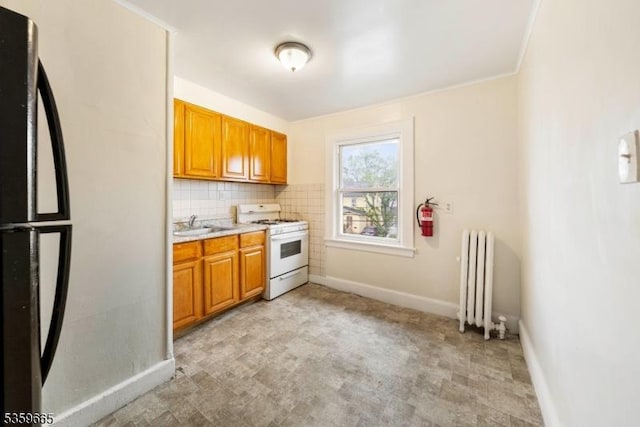 28 Beechwood Pl, Irvington Twp, NJ 07111 - kitchen featuring white range with gas stovetop, radiator, freestanding refrigerator, light countertops, and brown cabinetry