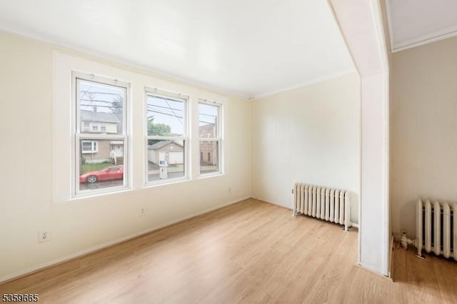 28 Beechwood Pl, Irvington Twp, NJ 07111 - empty room featuring radiator heating unit, light wood-type flooring, and crown molding