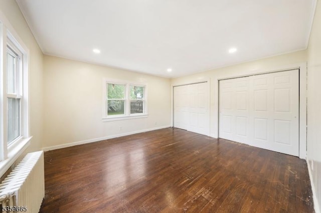 28 Beechwood Pl, Irvington Twp, NJ 07111 - unfurnished bedroom featuring radiator heating unit, multiple closets, hardwood / wood-style flooring, baseboards, and recessed lighting