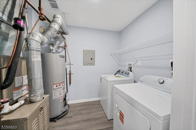 173 Gregory Ln, Franklin Twp, NJ 08823 - laundry room with independent washer and dryer, gas water heater, electric panel, wood finished floors, and baseboards