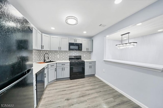 173 Gregory Ln, Franklin Twp, NJ 08823 - kitchen with black appliances, decorative backsplash, a sink, light countertops, and light wood-type flooring