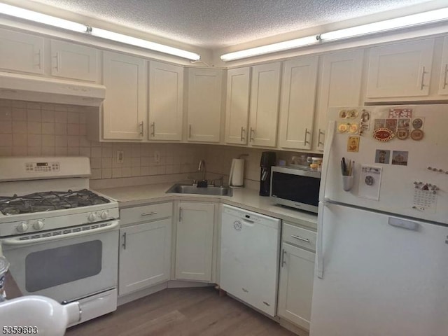167 Rachel Ct, Franklin Twp, NJ 08823 - kitchen with white appliances, under cabinet range hood, a sink, light countertops, and light wood finished floors