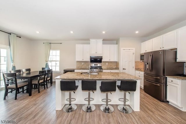 76 Trafalgar Ct, Sparta Twp, NJ 07871 - kitchen with stainless steel appliances, an island with sink, tasteful backsplash, white cabinetry, and recessed lighting