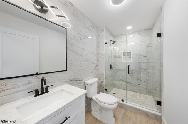 107 Myrtle St, Cranford Twp, NJ 07016 - bathroom with wood finished floors, vanity, a marble finish shower, toilet, and tile walls