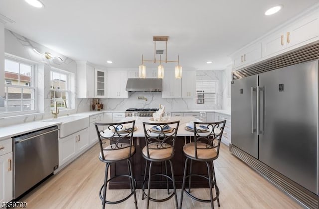 107 Myrtle St, Cranford Twp, NJ 07016 - kitchen with appliances with stainless steel finishes, under cabinet range hood, white cabinets, light wood-type flooring, and recessed lighting
