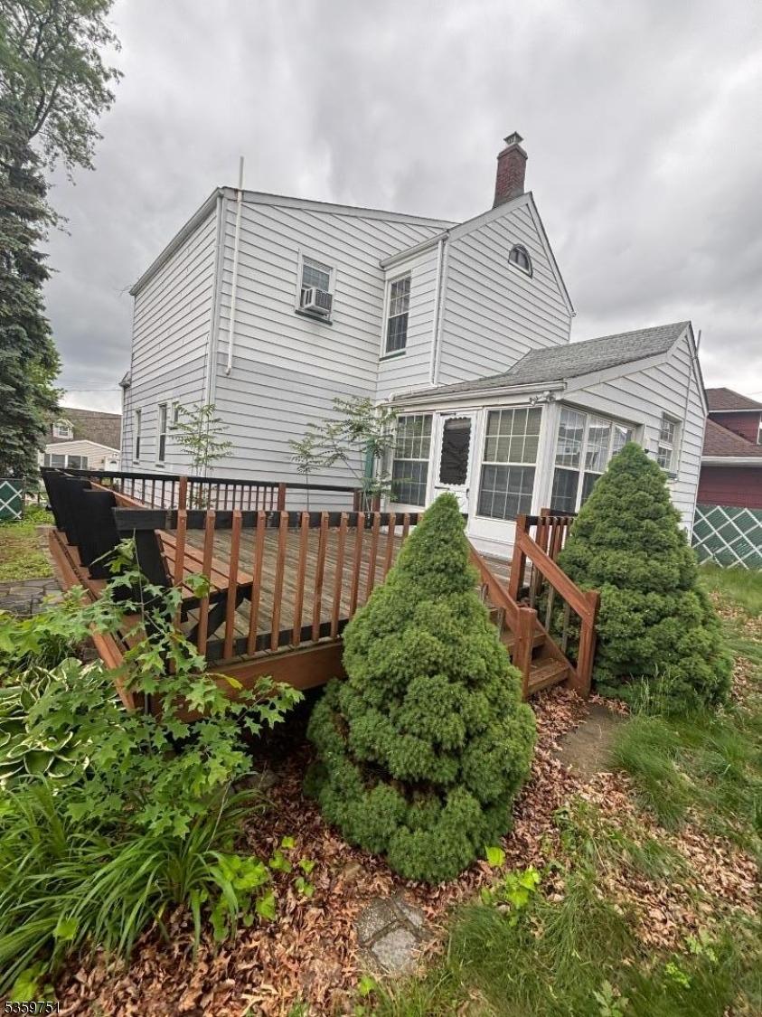 130 Riverview Ave, North Arlington Boro, NJ 07031 - back of property featuring a chimney, a deck, and a sunroom