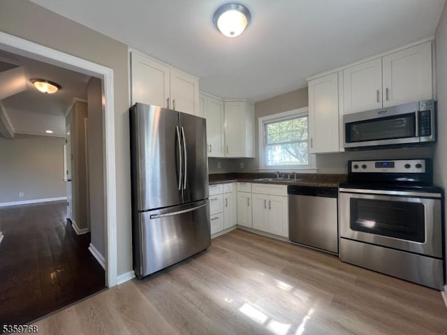 45 Park Ave, Newton Town, NJ 07860 - kitchen with appliances with stainless steel finishes, dark countertops, light wood-style flooring, and white cabinets