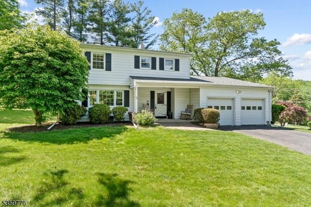 185 Ann St, Dover Town, NJ 07801 - view of front of house with an attached garage, driveway, and a front lawn