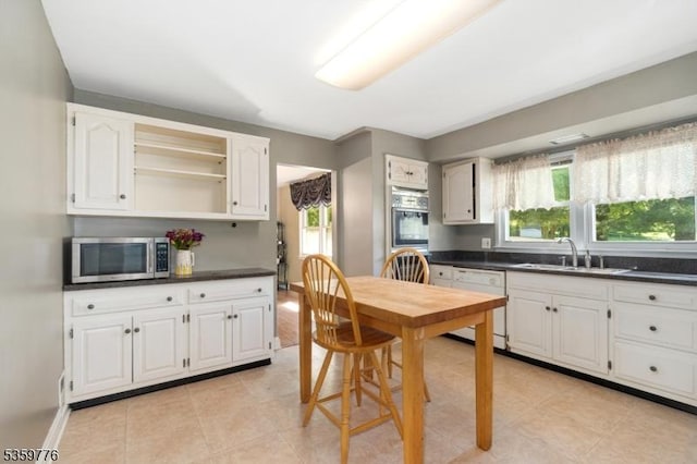 185 Ann St, Dover Town, NJ 07801 - kitchen featuring stainless steel microwave, a sink, white dishwasher, white cabinets, and dark countertops