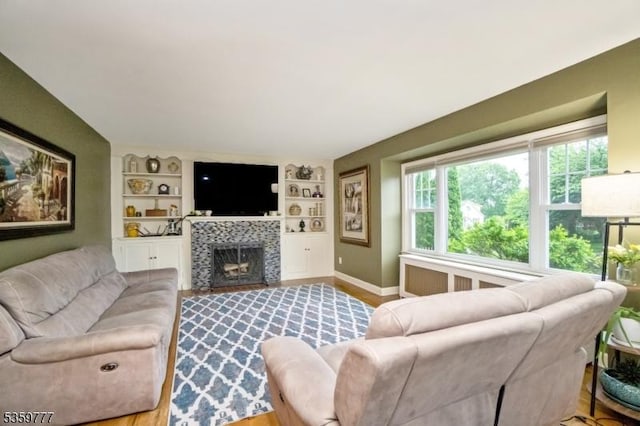 303 March Blvd, Pohatcong Twp, NJ 08865 - living area featuring baseboards, built in features, a tiled fireplace, and wood finished floors