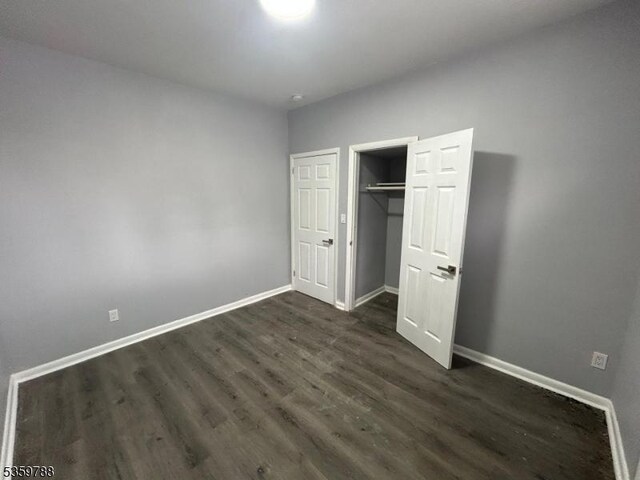 207 Tremont Ave, East Orange City, NJ 07018 - unfurnished bedroom with dark wood finished floors, baseboards, and a closet