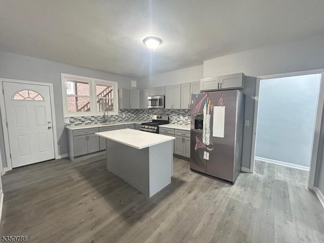 207 Tremont Ave, East Orange City, NJ 07018 - kitchen with appliances with stainless steel finishes, gray cabinetry, a sink, wood finished floors, and light countertops