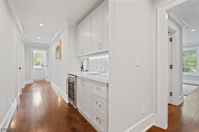 290 Long Hill Dr, Millburn Twp, NJ 07078 - indoor wet bar featuring wine cooler, ornamental molding, dark wood finished floors, healthy amount of natural light, and recessed lighting