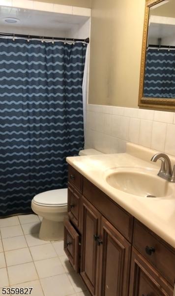 13 Elmwood Dr, Mansfield Twp, NJ 07840 - bathroom with vanity, toilet, tile walls, tile patterned flooring, and wainscoting