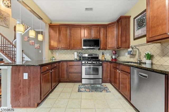 2420 Canterbury Ln, North Brunswick Twp, NJ 08902 - kitchen with appliances with stainless steel finishes, a sink, a peninsula, light tile patterned floors, and dark stone countertops