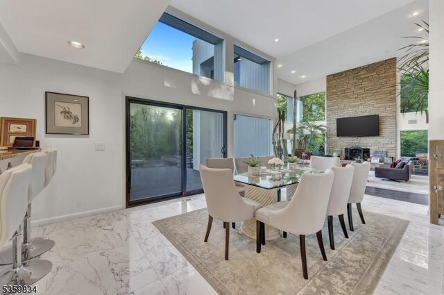 41 Park Way W, Orange Twp, NJ 07052 - dining area with light marble finish floors, a stone fireplace, baseboards, recessed lighting, and a towering ceiling