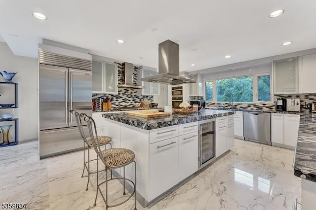 41 Park Way W, Orange Twp, NJ 07052 - kitchen featuring stainless steel appliances, island exhaust hood, beverage cooler, wall chimney range hood, and backsplash