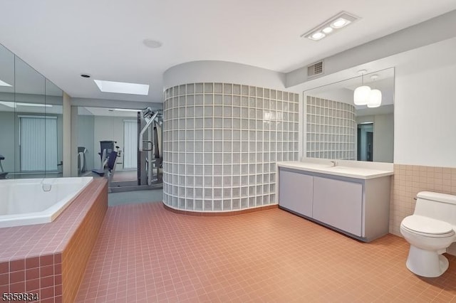 41 Park Way W, Orange Twp, NJ 07052 - bathroom featuring toilet, a skylight, tile walls, vanity, and a garden tub