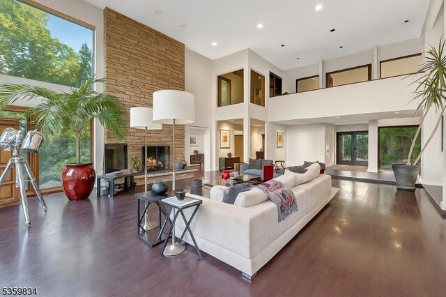 41 Park Way W, Orange Twp, NJ 07052 - living area featuring a stone fireplace, healthy amount of natural light, a high ceiling, and dark wood-style floors