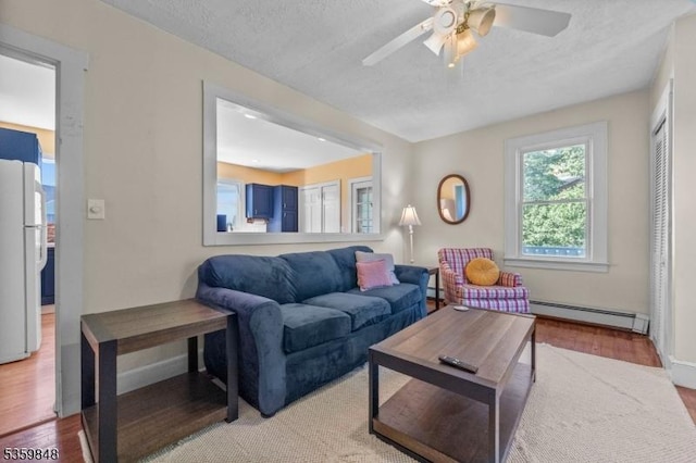 7 Shores Rd, Mendham Twp, NJ 07926 - living room featuring a baseboard heating unit, ceiling fan, light wood finished floors, baseboard heating, and baseboards