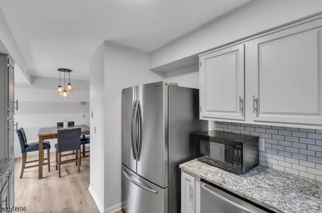 65 Academy Ct, Bedminster Twp, NJ 07921 - kitchen featuring appliances with stainless steel finishes, decorative backsplash, light wood-style flooring, light stone countertops, and white cabinets