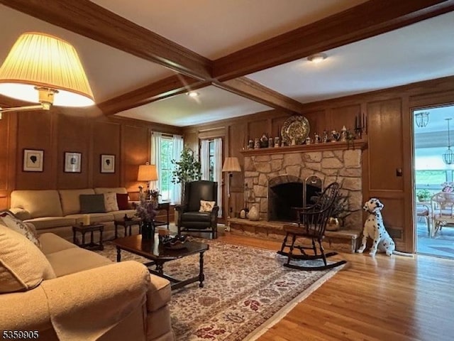 90 Locust Lake Rd, Hope Twp, NJ 07825 - living area featuring wood finished floors, beamed ceiling, healthy amount of natural light, a decorative wall, and a fireplace