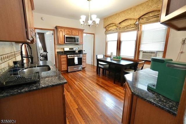 680 N 8th St, Newark City, NJ 07107 - kitchen featuring appliances with stainless steel finishes, dark wood-type flooring, a chandelier, cooling unit, and brown cabinetry