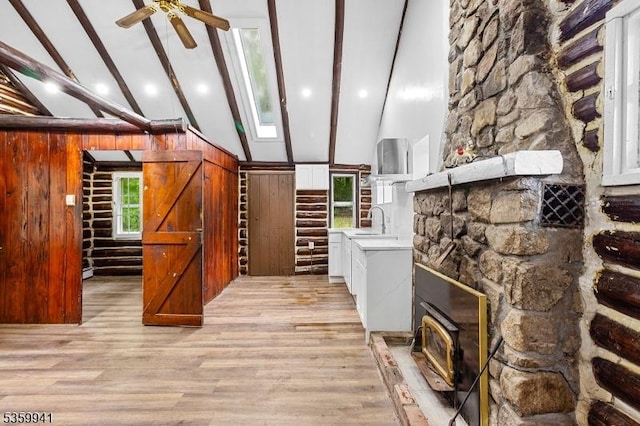 13 Alturas Rd, Vernon Twp, NJ 07422 - unfurnished living room with beam ceiling, high vaulted ceiling, light wood finished floors, ceiling fan, and a sink