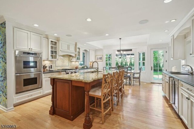 23 Parkview Rd, Chatham Twp, NJ 07928 - kitchen featuring stainless steel double oven, a sink, light wood-style flooring, recessed lighting, and decorative backsplash