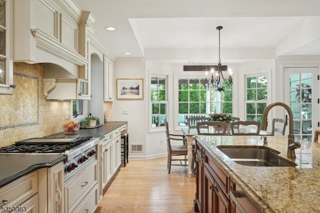 23 Parkview Rd, Chatham Twp, NJ 07928 - kitchen featuring a sink, light wood-style flooring, a chandelier, backsplash, and stainless steel gas cooktop