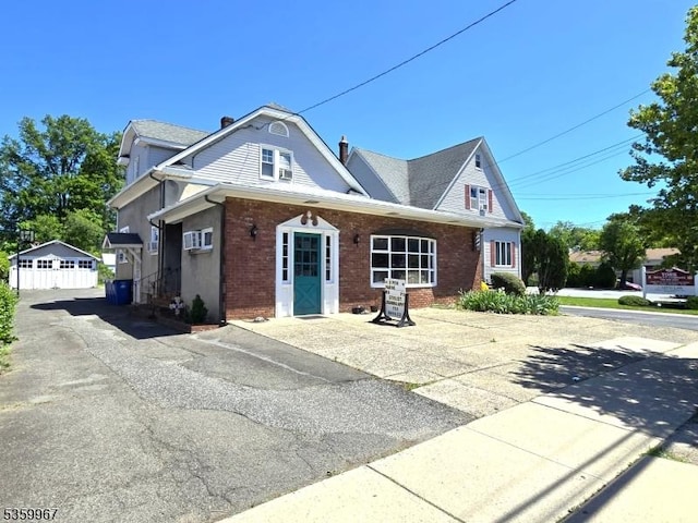307 W Union Ave, Bound Brook Boro, NJ 08805 - view of front of house featuring brick siding, a chimney, and a garage